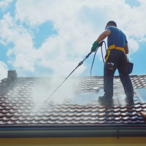 Man cleaning a weathered tile roof. Blue sky, Man cleaning a weathered tile roof. Blue sky, High pressure cleaning. outdoor. Created by ai